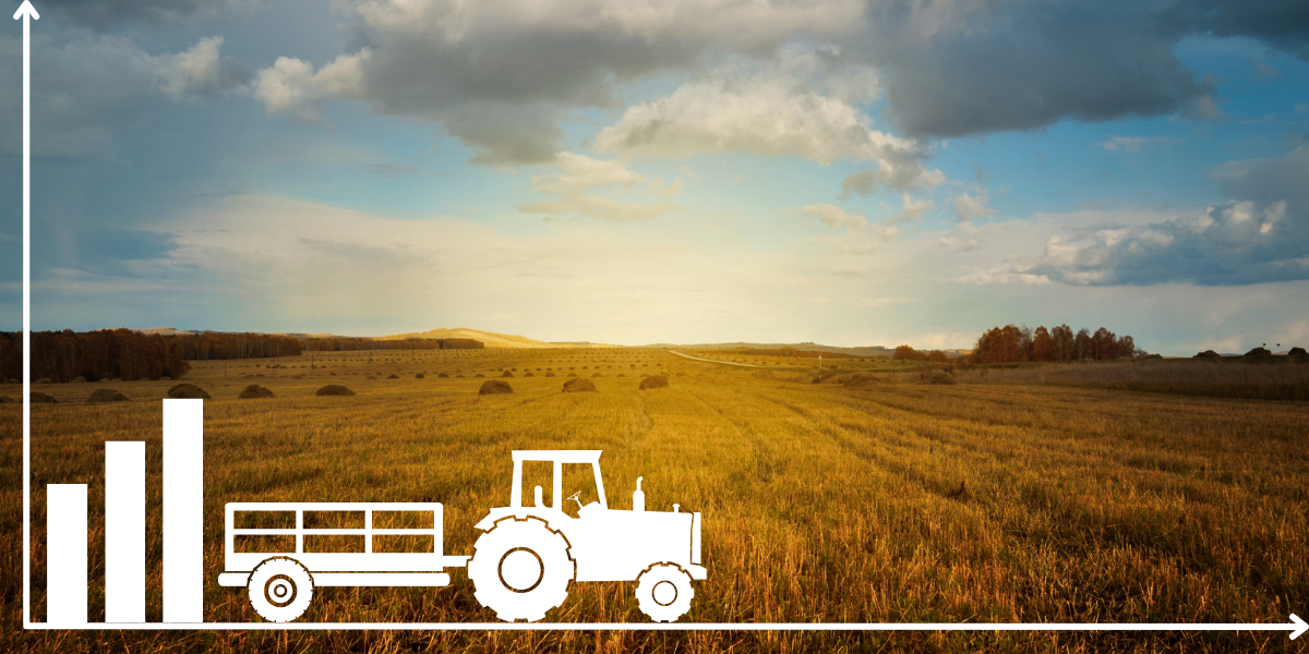 Traktor vor einem abgeernteten Getreidefeld im Herbst.