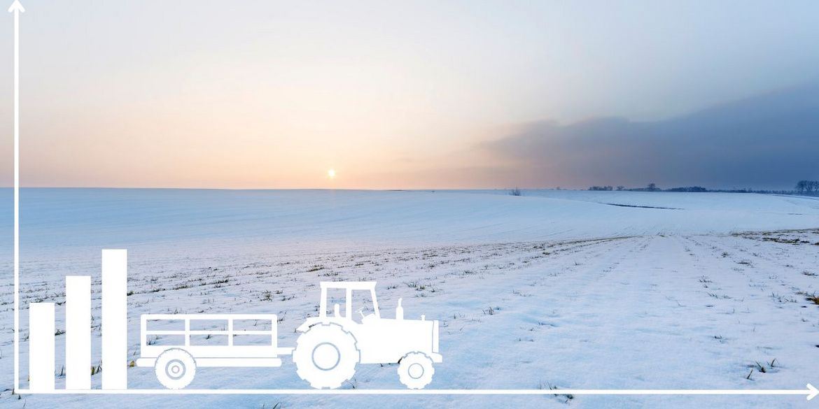 Traktor vor einem Feld mit Schnee.