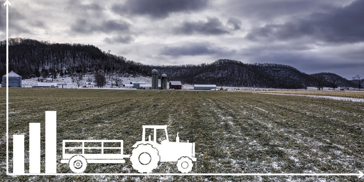 Traktor auf einem Feld vor einem landwirtschaftlichen Betrieb