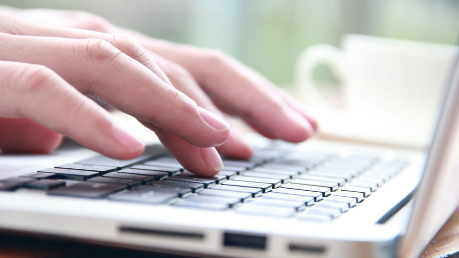 Weibliche Hand tippt auf Laptop